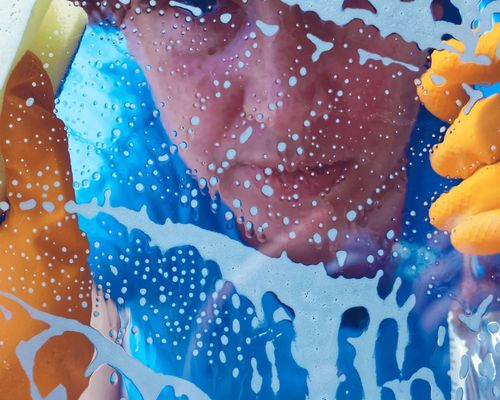 woman cleaning foggy window